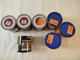 five cans of paint and a can of paint on a table