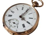 a gold pocket watch with roman numerals on it