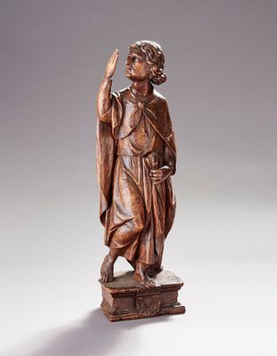 une statue en bois représentant un homme tenant un oiseau au-dessus d'une boîte