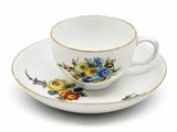 une tasse et une soucoupe sur une soucoupe sur une surface blanche