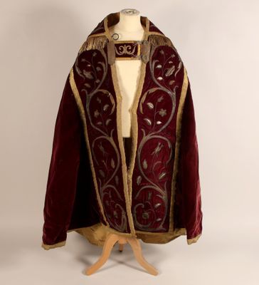 un gros plan d'une robe rouge et dorée sur un mannequin