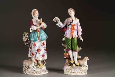 pair of porcelain figurines of a man and a woman with a dog