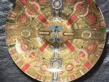 un plateau en or orné d'une horloge, posé sur un tissu noir