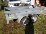 a small trailer that is parked in the grass