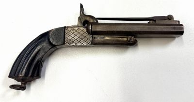 un vieux pistolet posé sur une surface blanche