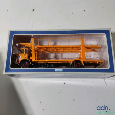 un camion miniature qui se trouve dans une boîte posée sur une table