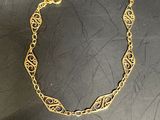 gros plan d'un bracelet en or sur une surface noire
