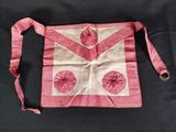 un vieux sac rose et blanc orné d'un ruban rose sur fond noir