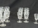 six verres à vin transparents sont alignés sur un fond noir