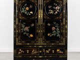 une armoire noire ornée de fleurs et d'oiseaux peints