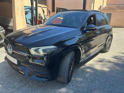 un SUV Mercedes noir garé devant un immeuble
