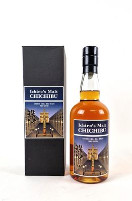 a bottle of whisky sitting next to a box on a white surface