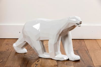 a white bear statue sitting on the floor in a room