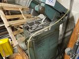 a machine that is sitting next to a pile of wood