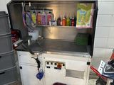 a kitchen with a sink and a trash can in it