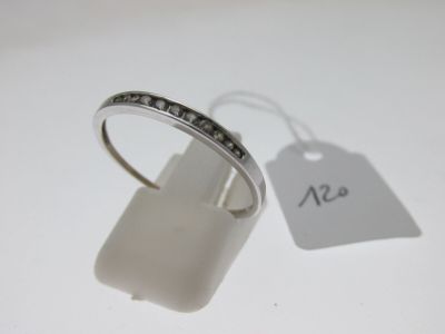 une bague en argent sertie de diamants noirs, à côté d'une étiquette de prix