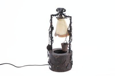 a lamp that has a bell hanging from it ' s side