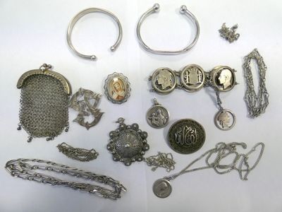 a lot of silver jewelry on a white surface