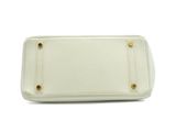 a white purse on a white background with a gold clasp