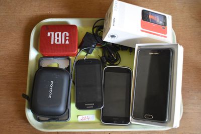 a tray with cell phones and a charger on it