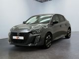 Une voiture grise est garée dans une grande pièce aux murs blancs