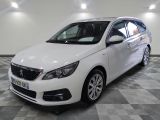 la voiture blanche est garée sur un sol en damier dans le garage