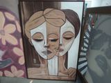 painting of two women with faces painted on a wall in a room
