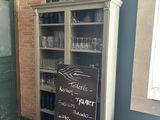 a chalk board that is on the floor in front of a bookcase
