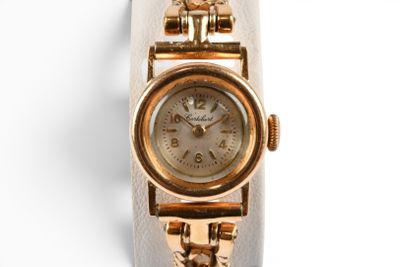 gros plan d'une montre-bracelet en or sur une surface blanche