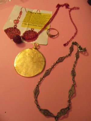 une table rose sur laquelle sont posés un collier, un bracelet et une bague