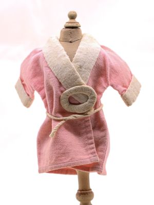 une robe rose sur un mannequin, avec une bague au doigt