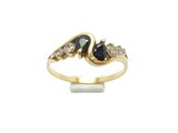gros plan d'une bague en or avec un saphir et des diamants