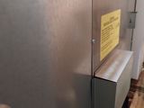 an image of a stainless steel refrigerator with a sign on the door