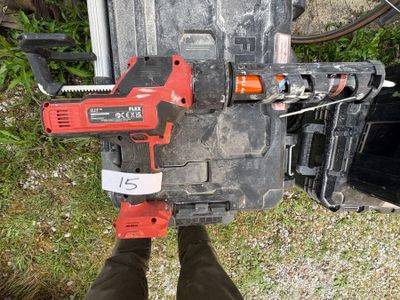 une personne debout à côté d'une boîte à outils, tenant un marteau