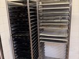 une étagère métallique avec des plateaux de nourriture dans une cuisine