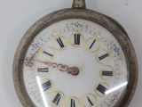 a silver pocket watch with roman numerals on it