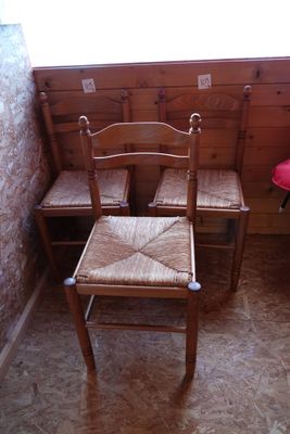 trois chaises en bois dans un coin de la pièce
