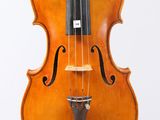 an old violin sitting on top of a white surface