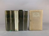 three books are lined up in a row next to a box