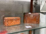 deux malles exposées dans une vitrine