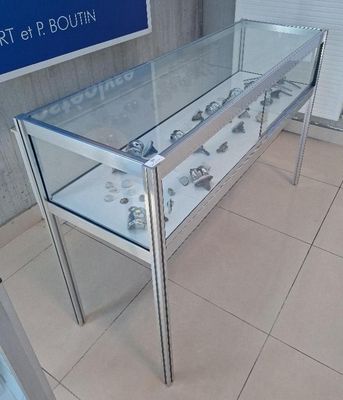 a glass display case with a lot of silver objects on it