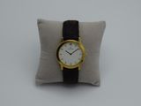 a close up of a wrist watch on a pillow on a white surface