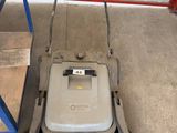 an image of a push mower in a garage