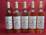 six bottles of wine are lined up on a red background