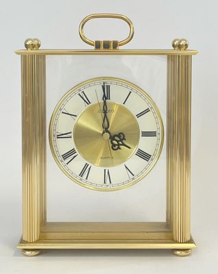 une horloge en or avec des chiffres romains sur le cadran