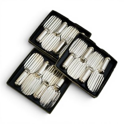 three silver plated utensils in a black box on a white surface