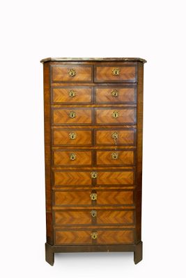 une commode ancienne avec un plateau en bois et des ferrures en laiton