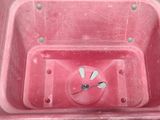 a pink container with a clock inside of it