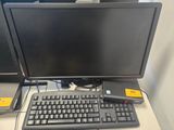 un écran d'ordinateur et un clavier posés sur un bureau