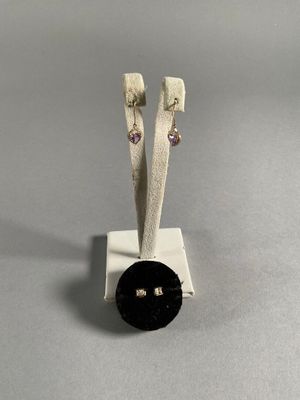 pair of black and white earrings with a black button on a white stand